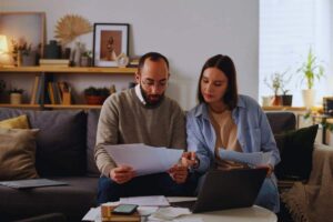 Coppia che controlla le note spese dal divano di casa