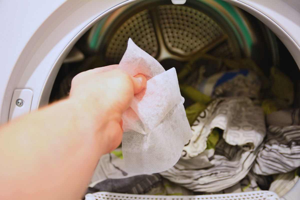 Donna che inserisce un foglietto nell'asciugatrice