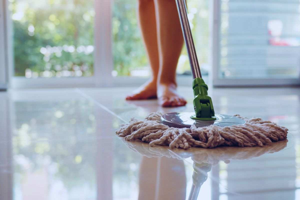 Donna che pulisce pavimento di casa