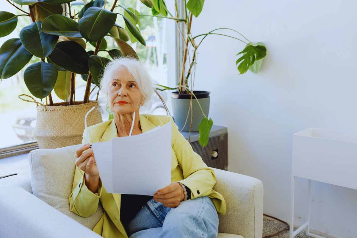 Donna anziana con documento tra le mani