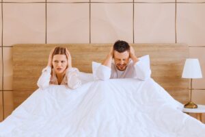 Coppia che si tappa le orecchie a letto a causa del forte rumore