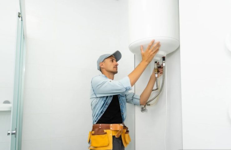 operaio si occupa della manutenzione dello scaldabagno