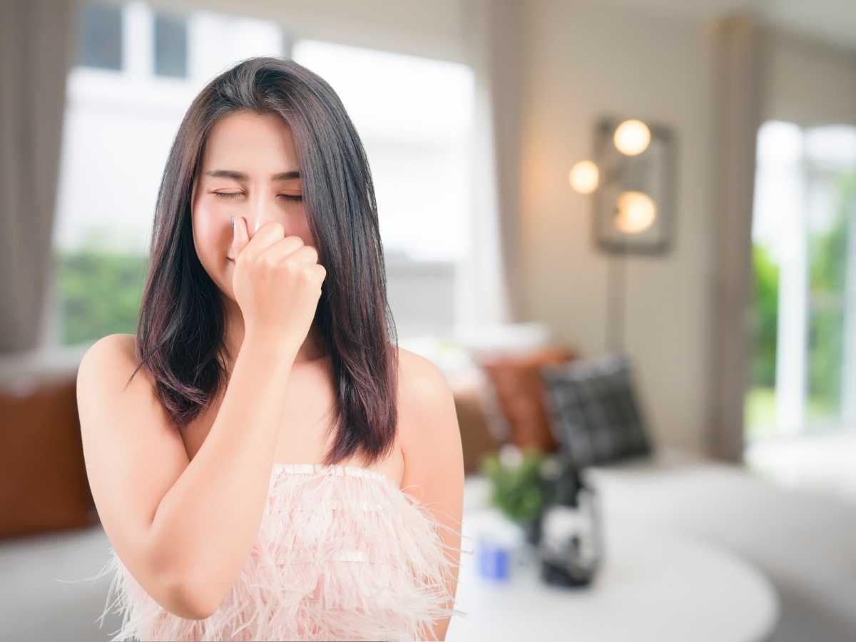 sfondo salotto, primo piano donna che si attappa il naso