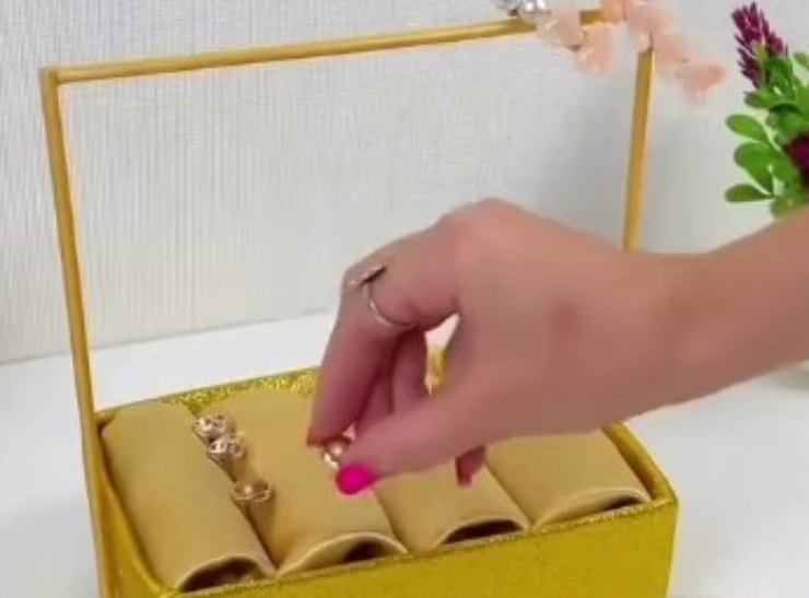 Donna che dispone gioielli in un portagioie handmade