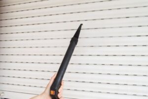 persona con lo strumento per pulire le tapparella in mano