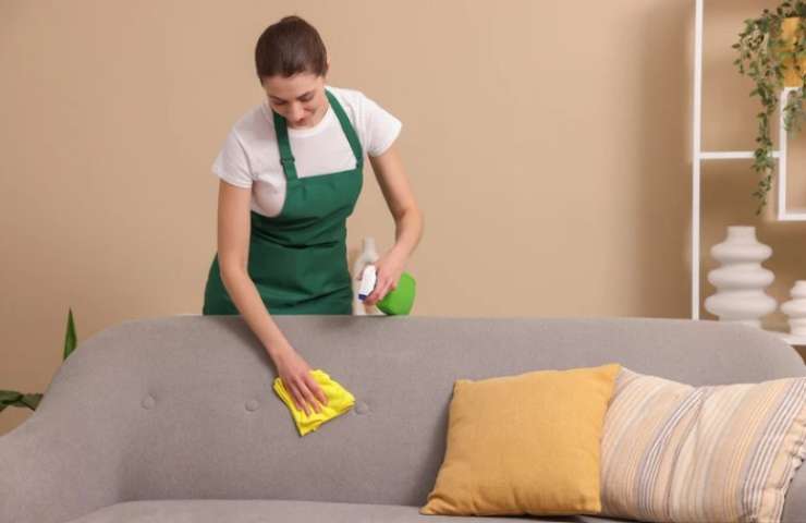 Donna pulisce il divano 