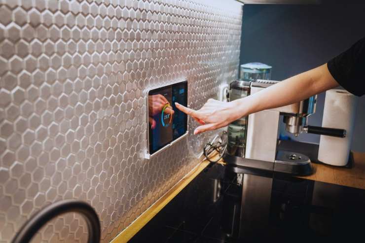 Uomo che imposta termostato di casa