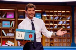 Stefano De Martino all'interno dello studio di Affari Tuoi con un pacco in mano