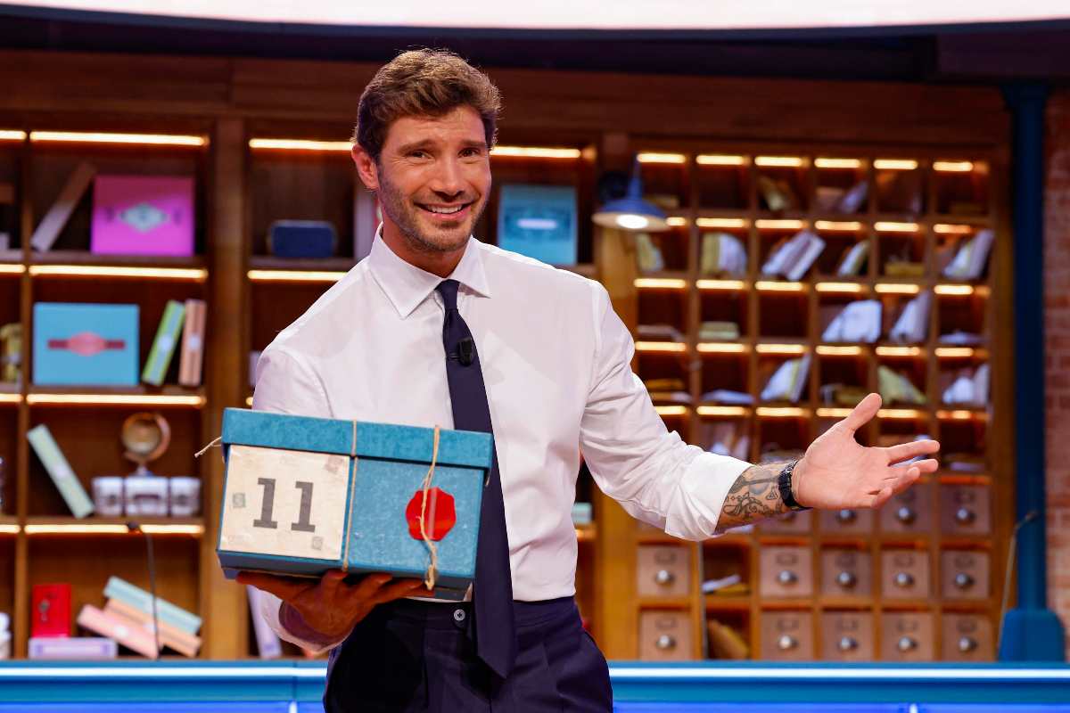 Stefano De Martino all'interno dello studio di Affari Tuoi con un pacco in mano