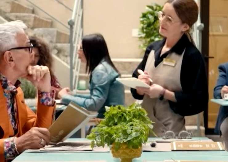 Bruno Barbieri che ordina nel ristorante di un hotel la colazione e cameriera che prende appunti