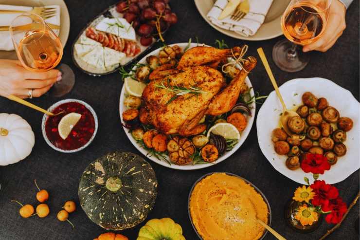 Tavola imbandita sulla quale troneggia un pollo arrosto