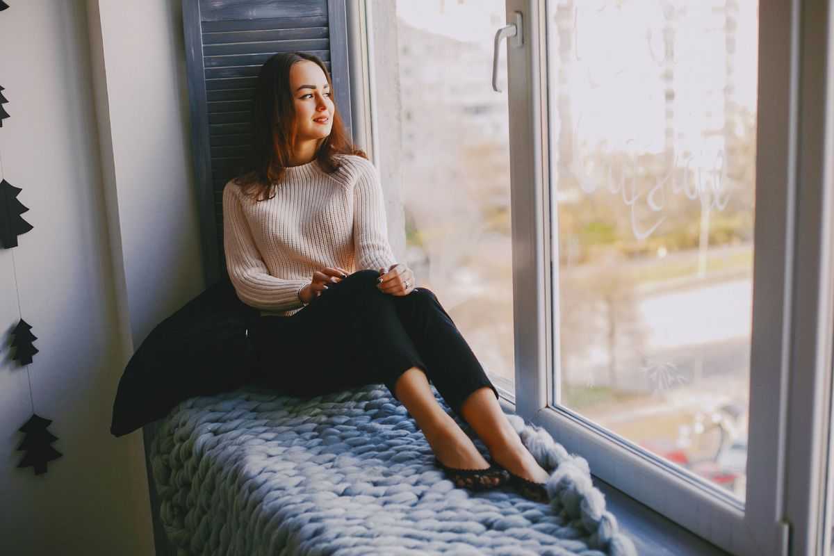 Ragazza che guarda il paesaggio dalla finestra