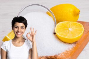 Donna che fa segno ok, davanti a limoni e acido citrico poggiati su tagliere in legno