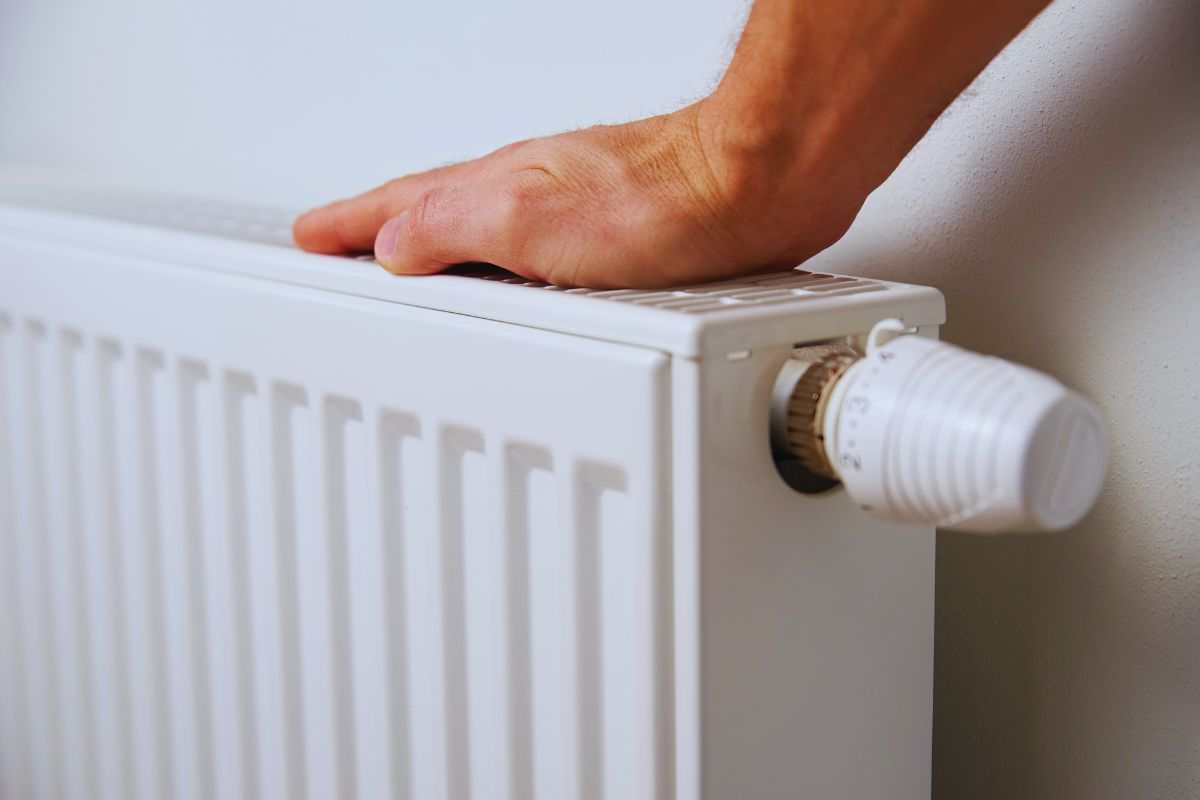Uomo che verifica resa termosifone con la mano