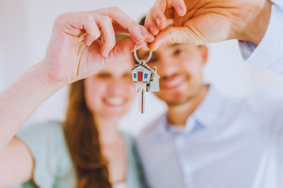 Coppia di giovani che tiene in mano le chiavi di casa