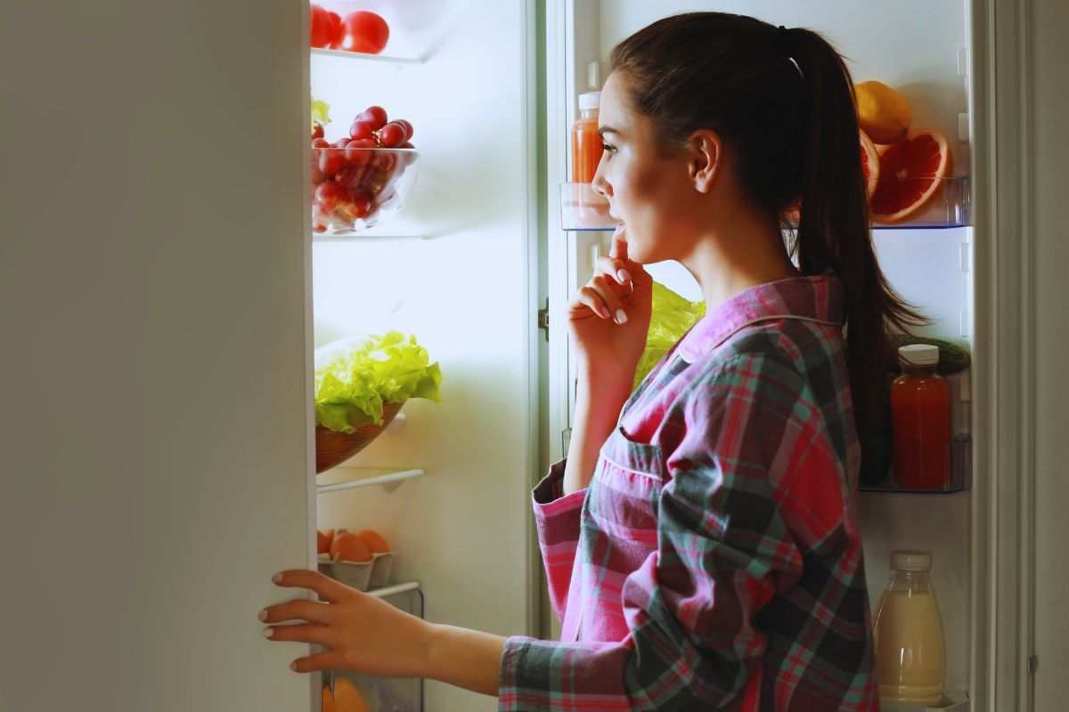 Donna che guarda dentro al frigo