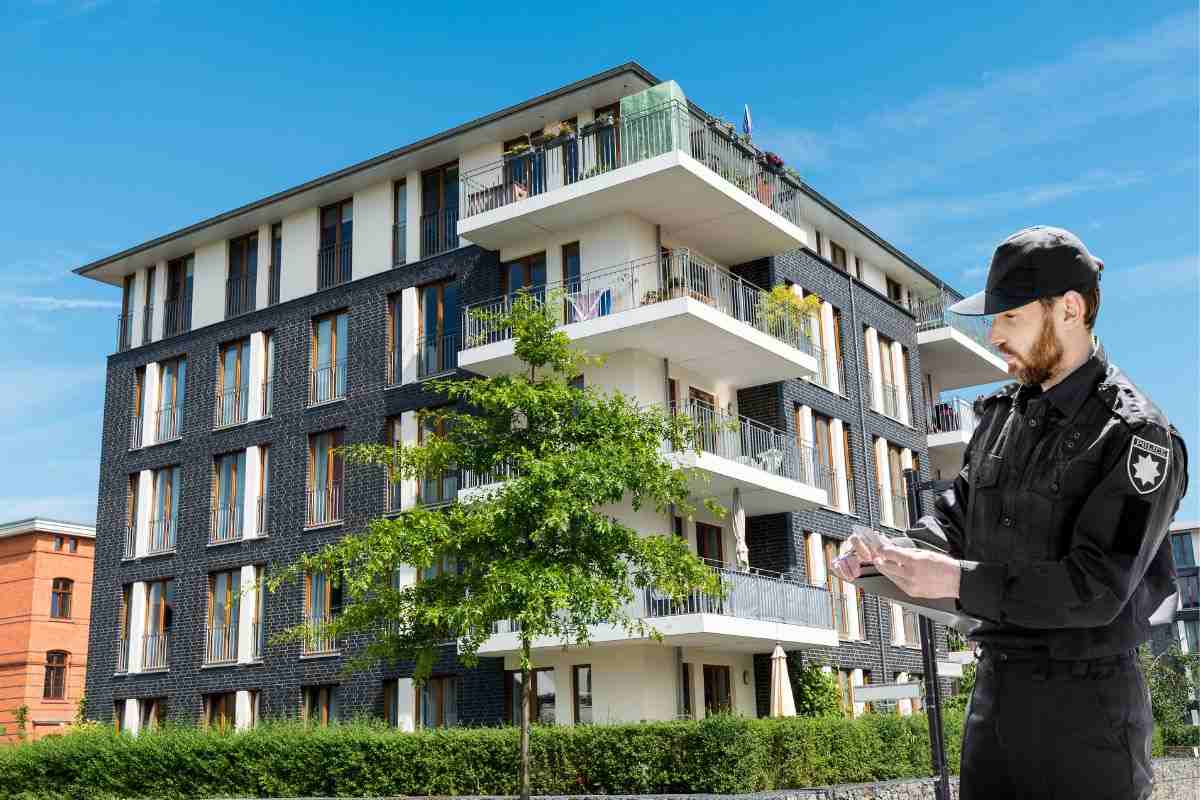 Agente che scrive multa davanti ad un palazzo condominiale