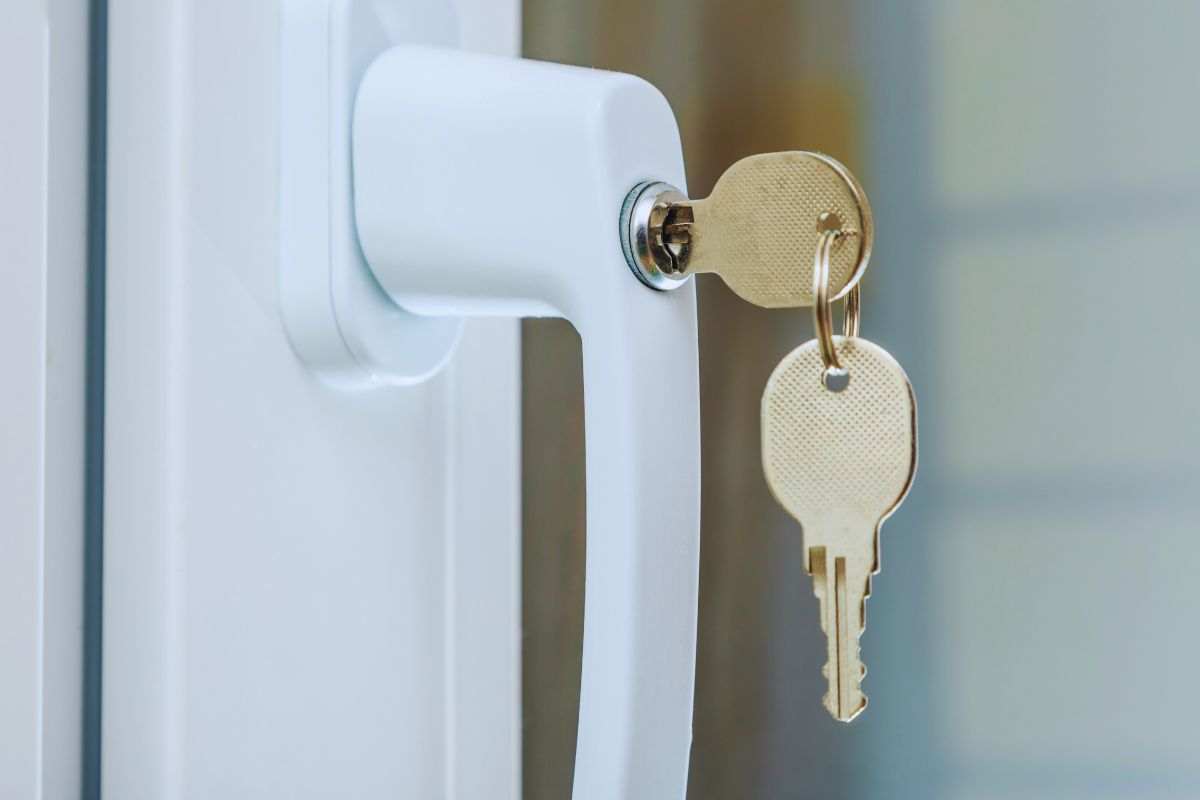 Maniglia finestra con serratura a cui sono appese le chiavi