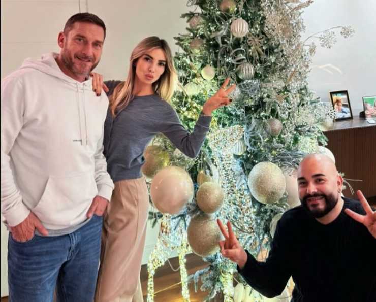 Francesco Totti, Noemi Bocchi e un loro amico davanti all'albero di Natale