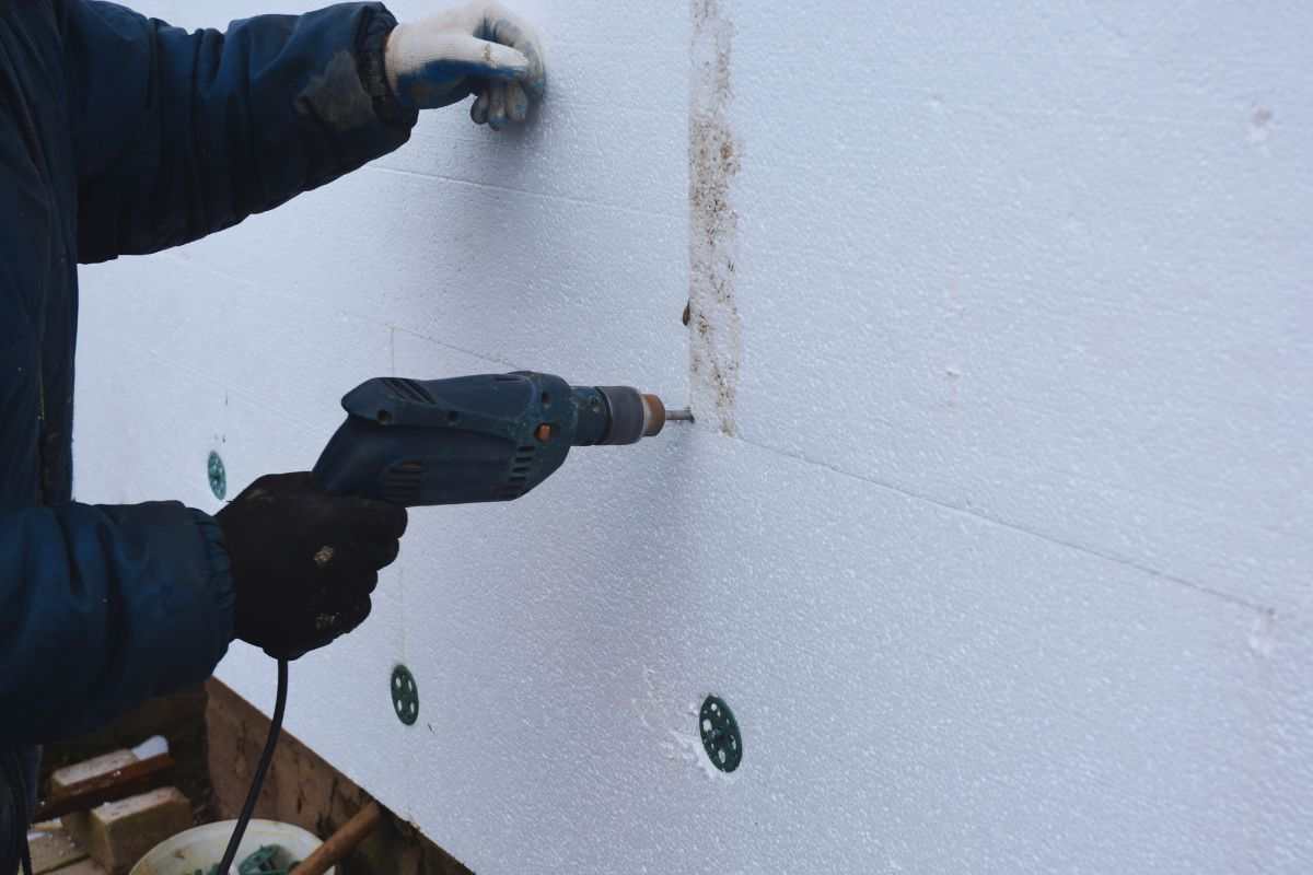 Uomo che isola parete di casa