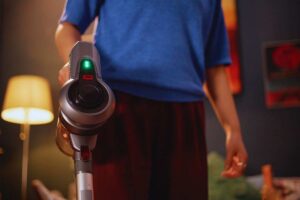 Persona che utilizza un aspirapolvere senza fili