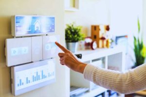 Donna che gestisce le tecnologie smart della sua casa tramite il pannello di controllo installato a parete