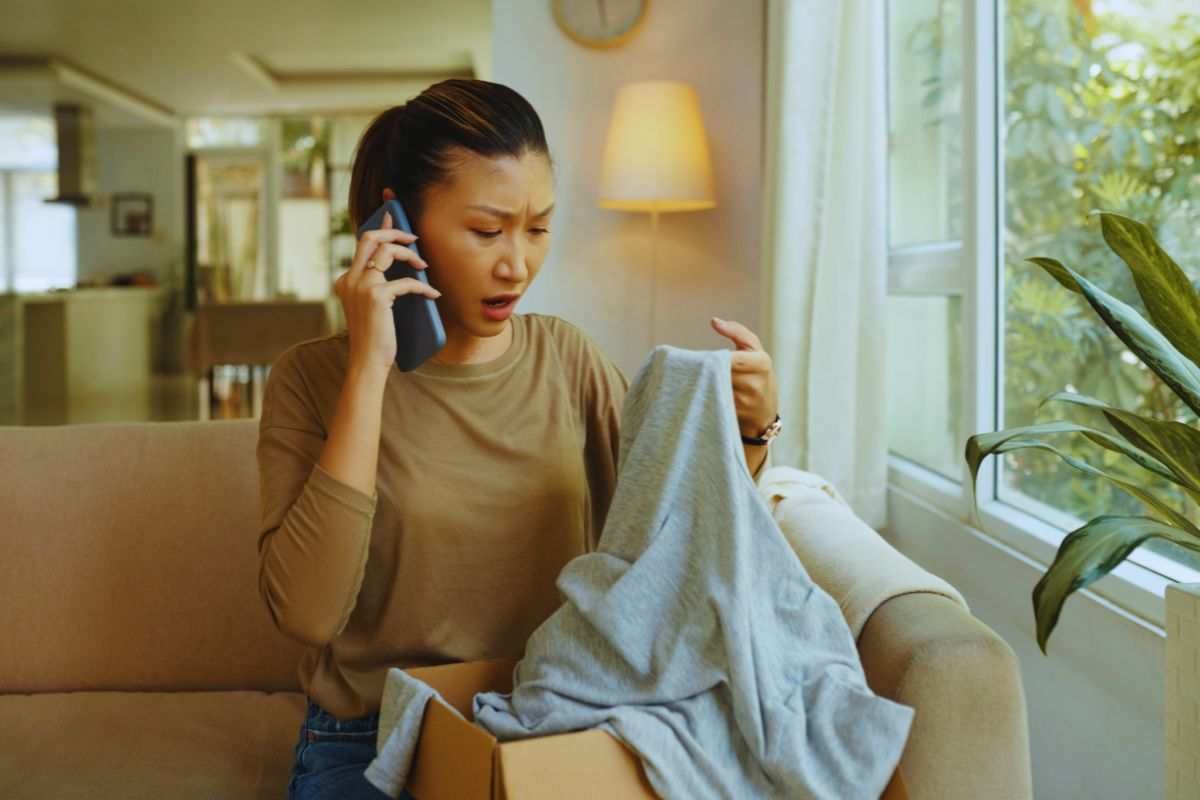 Donna che trova un maglione rovinato in una scatola