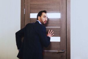 Uomo che poggia orecchio alla porta per ascoltare