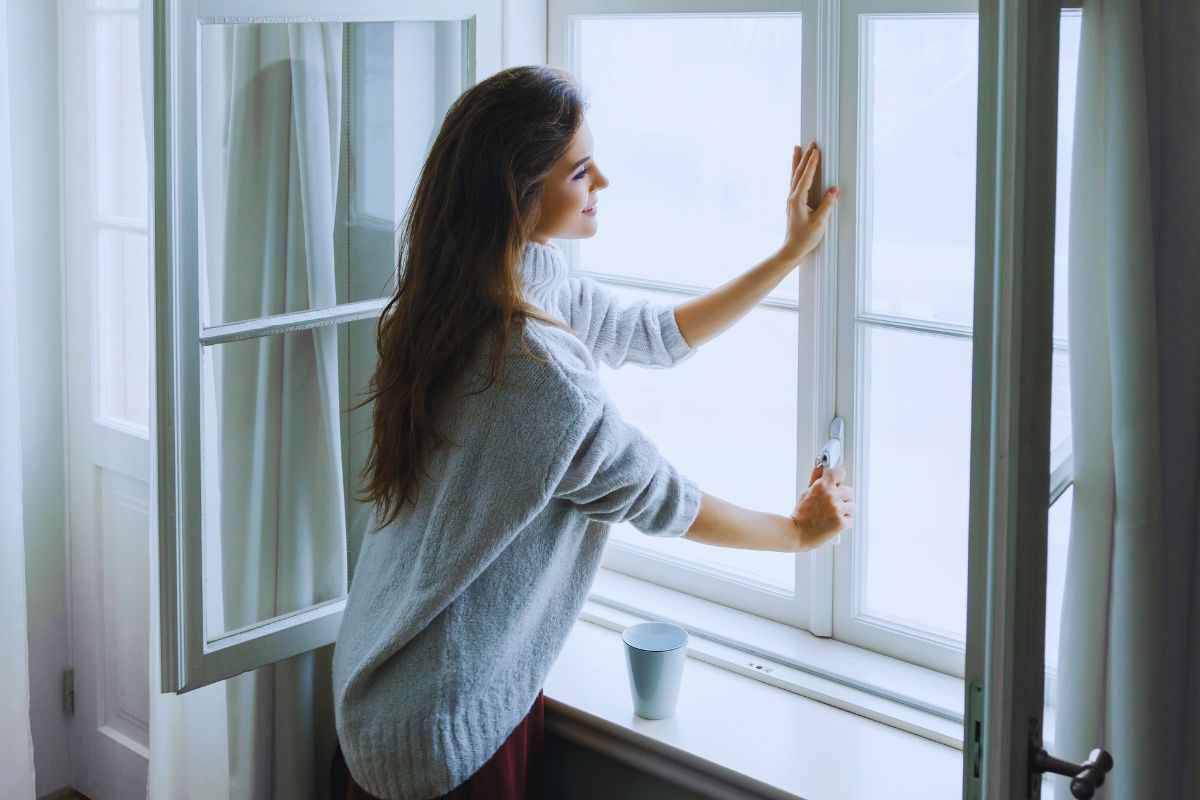 Ragazza che apre finestra di casa