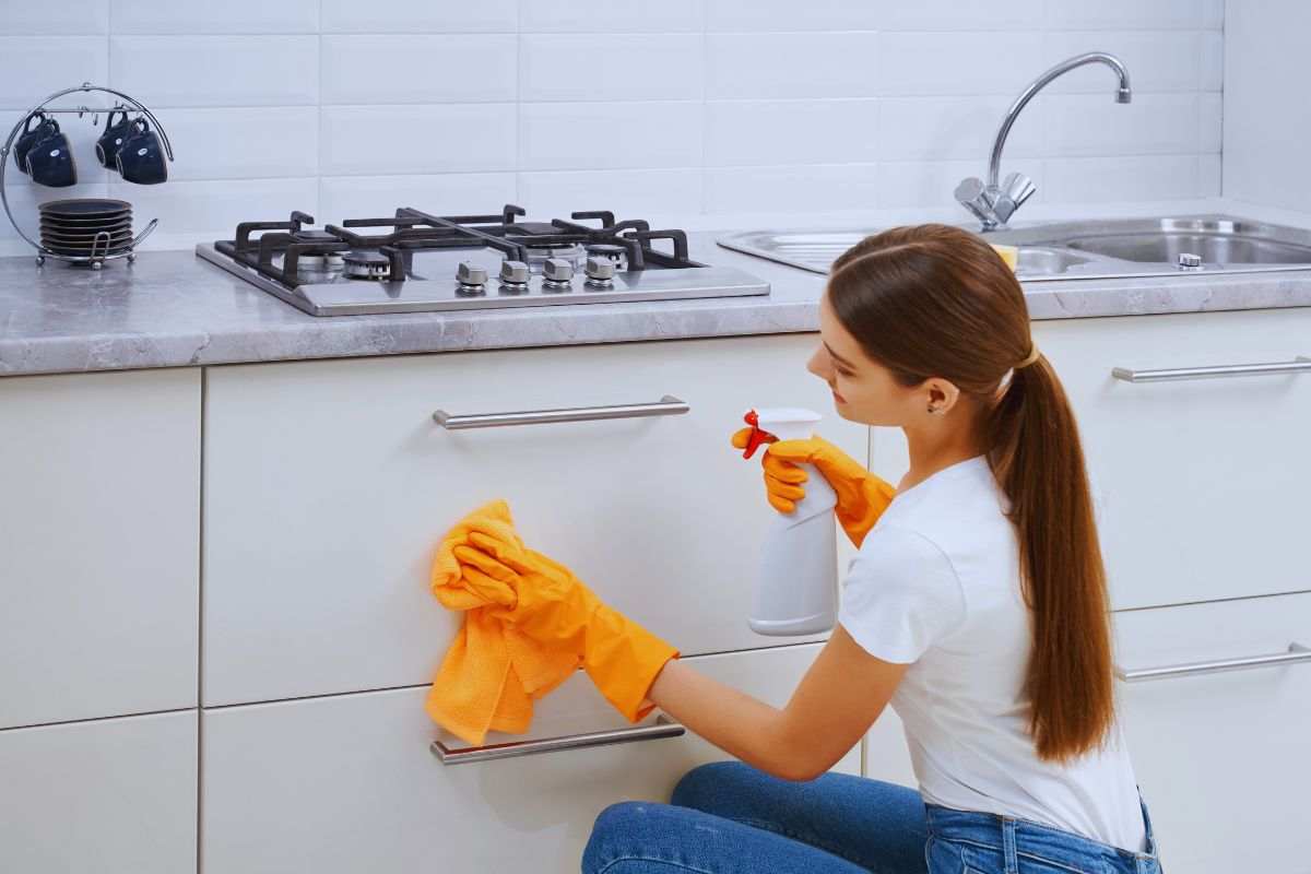 Ragazza che pulisce cassetti cucina