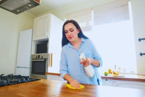 Donna che pulisce il piano cottura