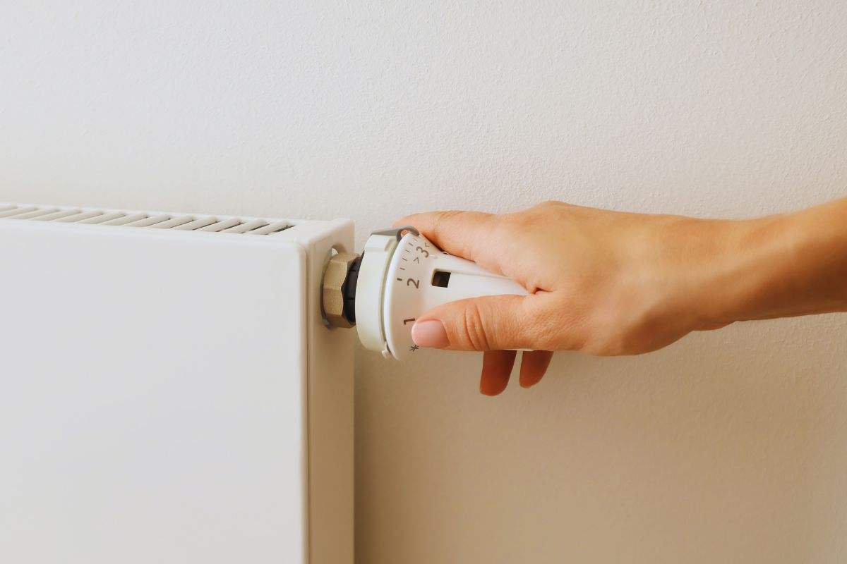 Persona che regola intensità calore termosifone