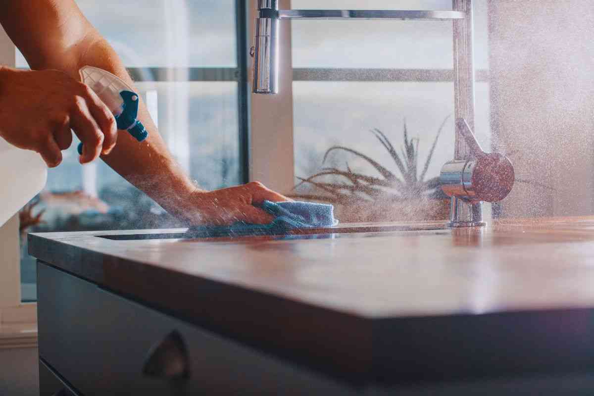 Donna che pulisci piano cottura